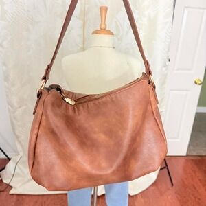 Tan leather shoulder bag with gold hardware and zipper closure